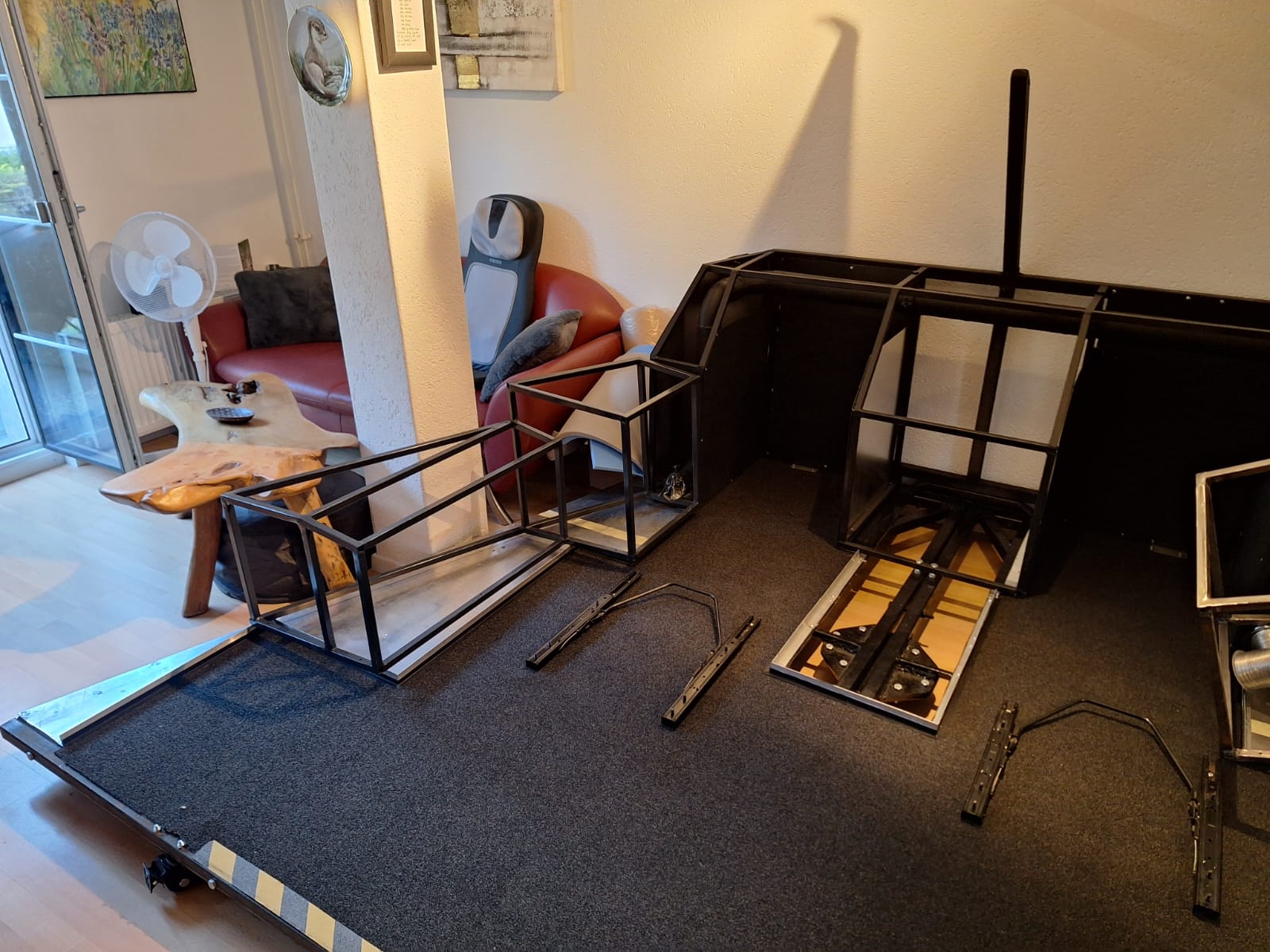 Rahmen des Flugsimulators in einem Wohnzimmer – erste Konstruktion des Cockpits mit Sitzen und Pedalen.