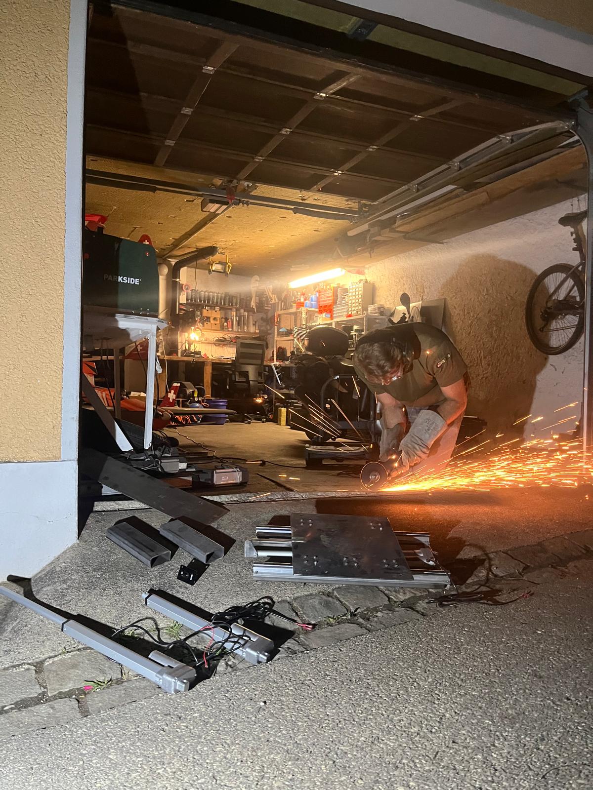 Werkstattfoto mit Funkenflug beim Schleifen des Metallrahmens des Flugsimulators.